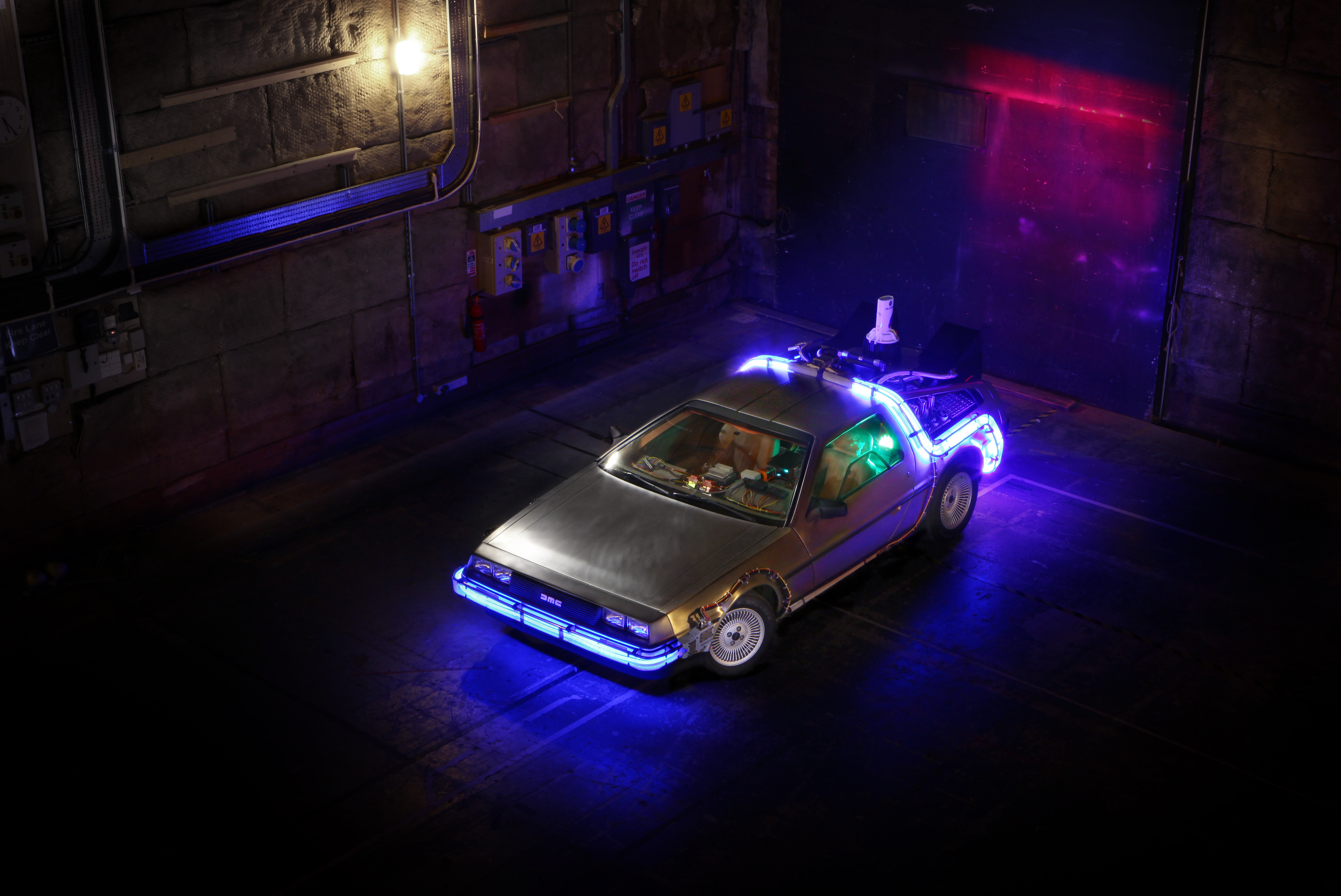 DeLorean overhead view with blue neon lighting in industrial setting